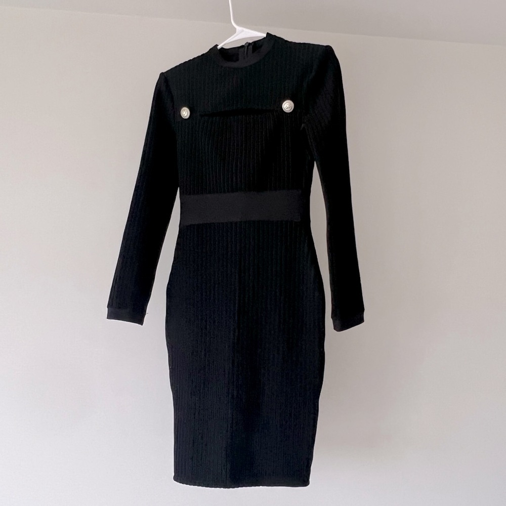 Knee length long sleeve cut out dress in black.